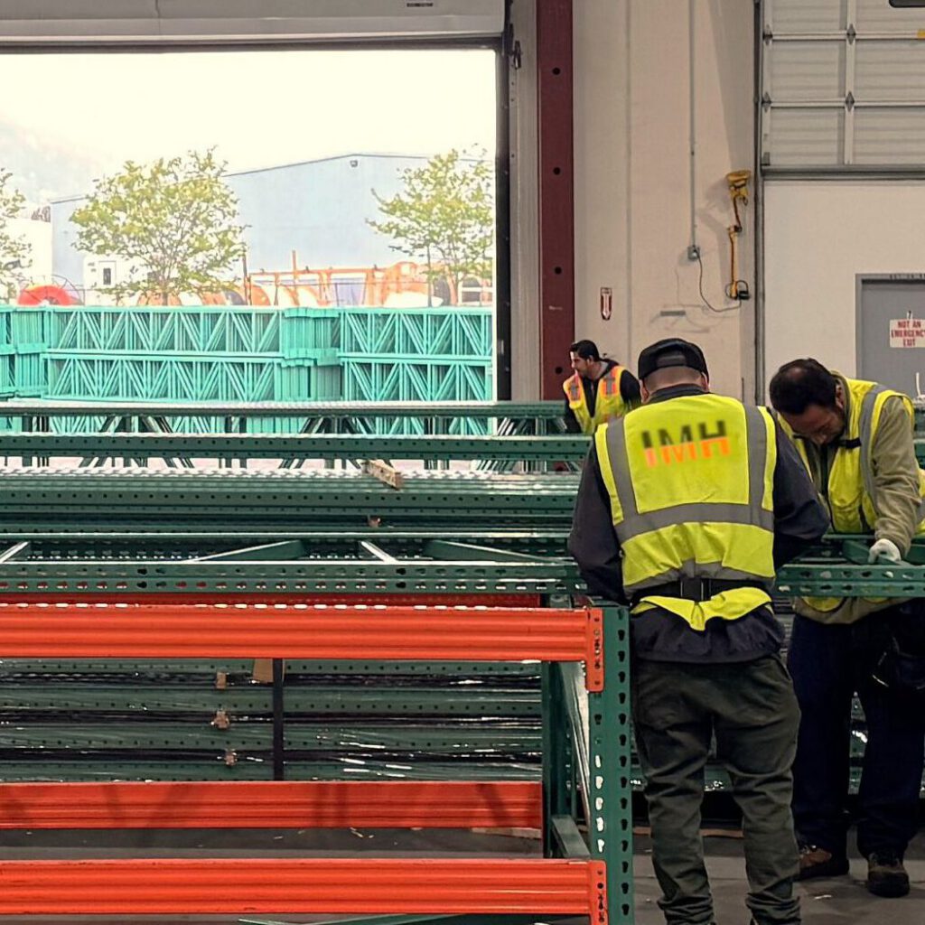 IMH team assembling green uprights and orange beams in riverside